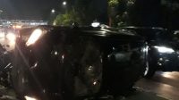 Mobil Hitam Terguling Setelah Tabrak Pembatas Jalan di Cawang, Pengemudi Perempuan Langsung Dilarikan ke RS